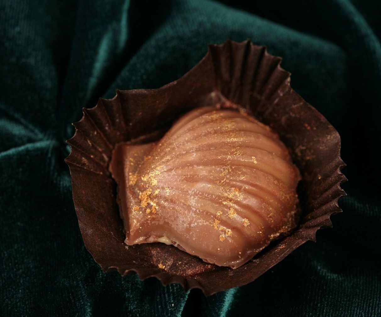Manos preparando bombones de chocolate en la mesa de trabajo